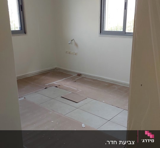 חדר עם רצפה מכוסה בקרטון להגנה מצבע